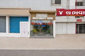 Un hotel llamado MIDWAY INN con un letrero que indica que está abierto.