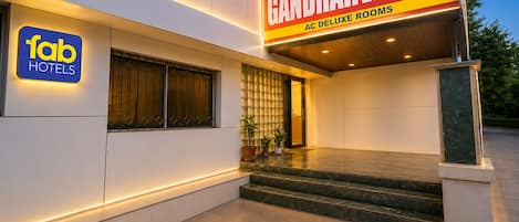 A hotel entrance with a sign for Gandharva Inn and a sign for Fab Hotels.