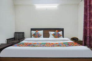 A hotel room with a bed, a nightstand, a telephone, and a curtain. - FabHotel Maharaja Palace (Haridwar)