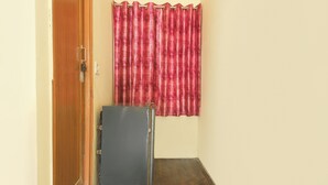 Un pasillo con una puerta de madera, una cortina roja y un armario gris.