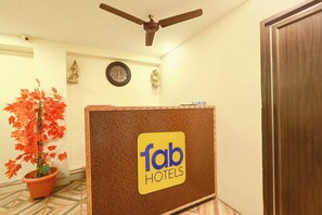 A reception area with a ceiling fan, a clock, a potted plant, and a sign for 'Tab Hotels'. - FabHotel Akshaya Bheemas Inn (Penumuluru)