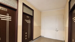 A hallway with two doors, one with a window and the other plain.