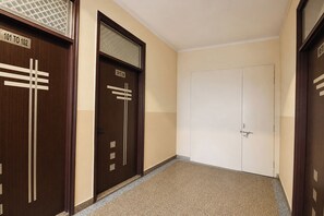 A hallway with two doors, one with a window and the other plain.