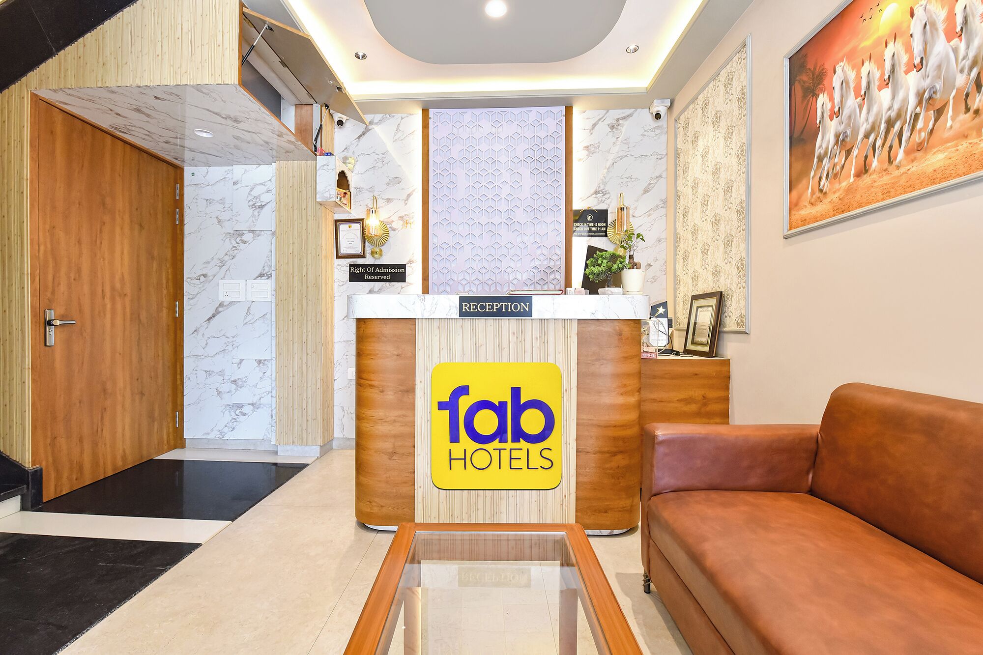 A reception desk with a 'fab hotels' sign, a reception area, a sofa, and a door.