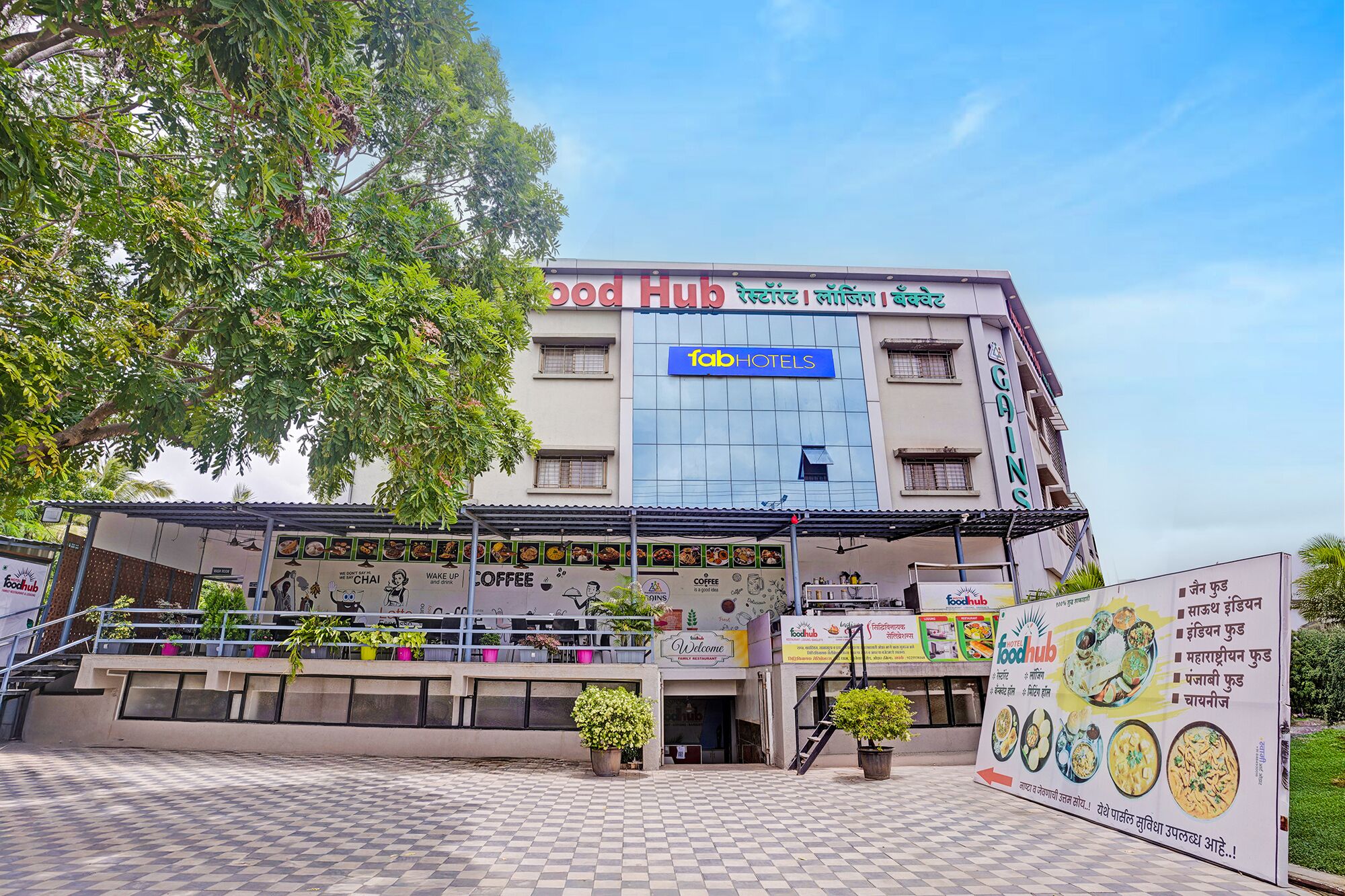 A building with a sign for 'fabHOTELS' and 'foodhub' on the facade.
