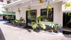 A building with multiple potted plants, hanging lights, and a tiled floor. - FabHotel Pontas Luxury Stay (Calangute)