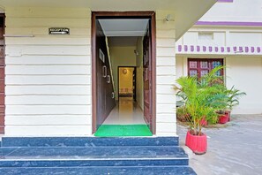 A reception area with a sign, a staircase, and potted plants. - FabHotel Cherish Stays (Ranchi)