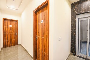 A hallway with two wooden doors, each marked with a number. - FabHotel Green Lotus (New Delhi)