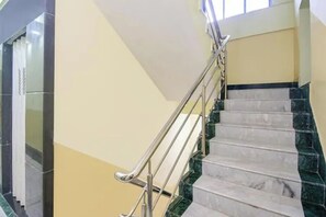 A staircase with marble steps and metal handrails, leading to an upper floor. - Via Om Shanti International (Kolkata)