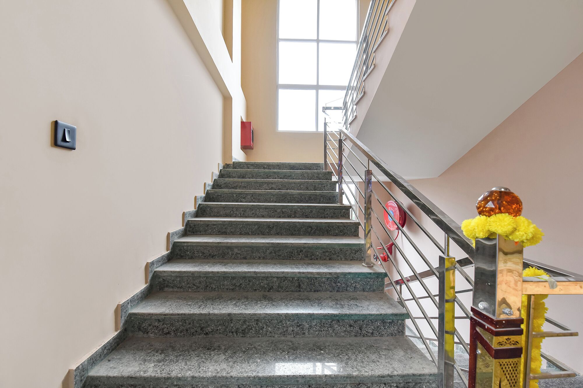 Una escalera con barandilla y un adorno amarillo en la parte superior.