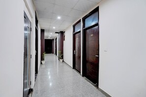 A corridor with doors numbered 204 and 203, leading to rooms. - Fabhotel Luxora (Noida)