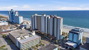 A coastal cityscape with high-rise buildings, a beach, and a parking garage. - 1 BR Oceanfront Pet Friendly Fall Upgrades! (Myrtle Beach)