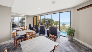 Habitació d'hotel amb una finestra gran, una piscina i una planta.