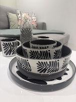 A set of black and white patterned bowls on a white table.