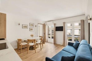 Ein modernes Wohnzimmer mit einem blauen Sofa, einem Holzesstisch und Stühlen.