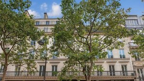 A building with a storefront labeled 'AU P'TIT PANAME' and 'DUNKIN' across the facade. - In the heart of Paris, new flat for 6, with AC (Paris)