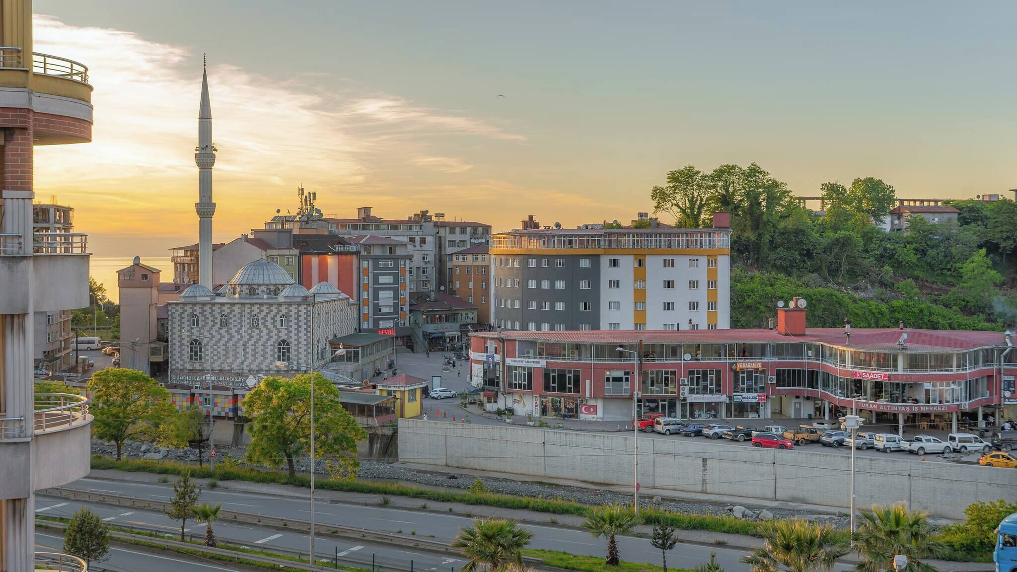 A cityscape with a prominent mosque, a modern building, and a mix of residential and commercial structures.