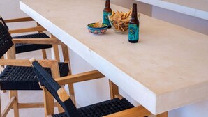 Ein Esstisch mit Stühlen, Flaschen und einer Schüssel Chips.