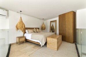 A modern bedroom with a wooden bed, a large wardrobe, and a hanging light fixture. - Ki'Che': An Intimate 1-Bedroom Loft (Tulum)