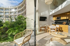 A modern apartment with a balcony, a dining area, and a kitchen. - Stunning Loft in Beautiful Building (Tulum)