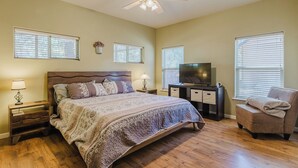 A bedroom with a bed, a TV, a chair, and a ceiling fan. - Single level 3 bedroom house in Pagosa Springs with a fenced backyard (Pagosa Springs)