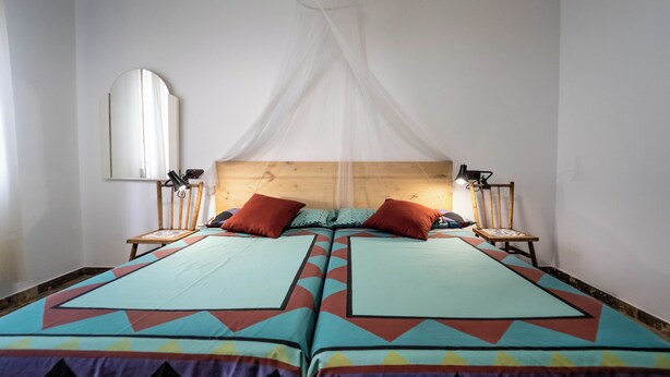 A double bed with a canopy, two bedside lamps, and a mirror on the wall. - Home, beach, and garden. (O Grove)