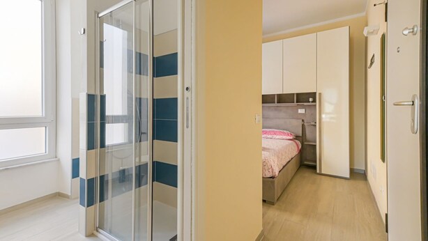Ein Schlafzimmer mit einem Bett, einem Kleiderschrank und einer Schiebetür.