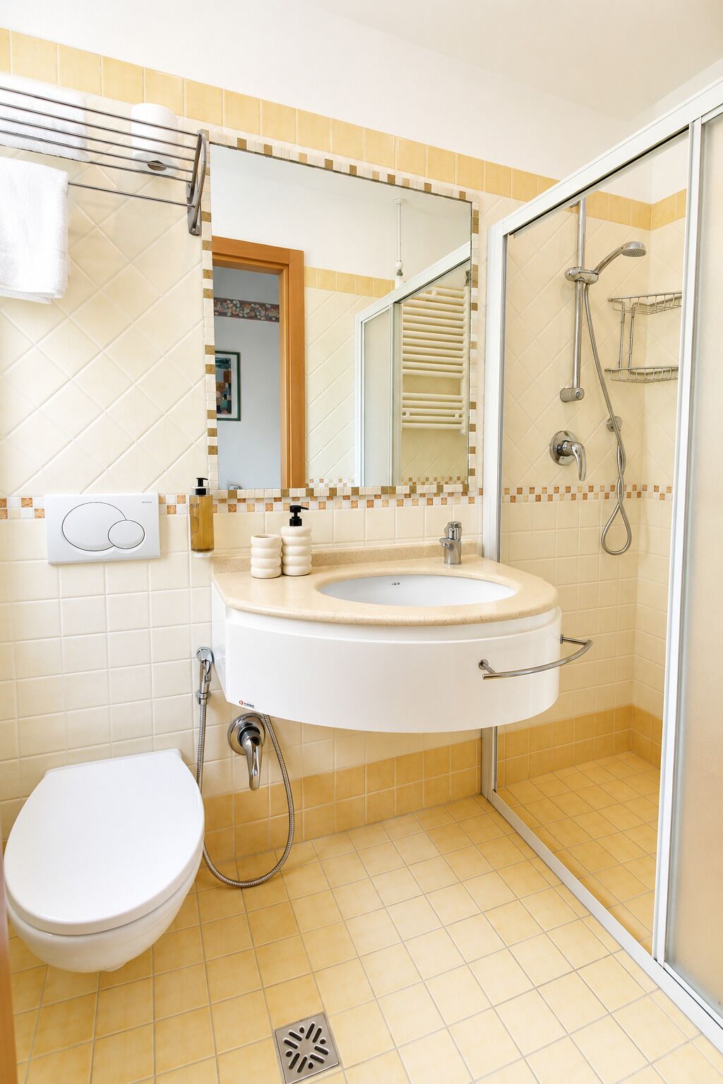 A bathroom with a white sink, a toilet, a shower with a glass door, and a mirror above the sink.