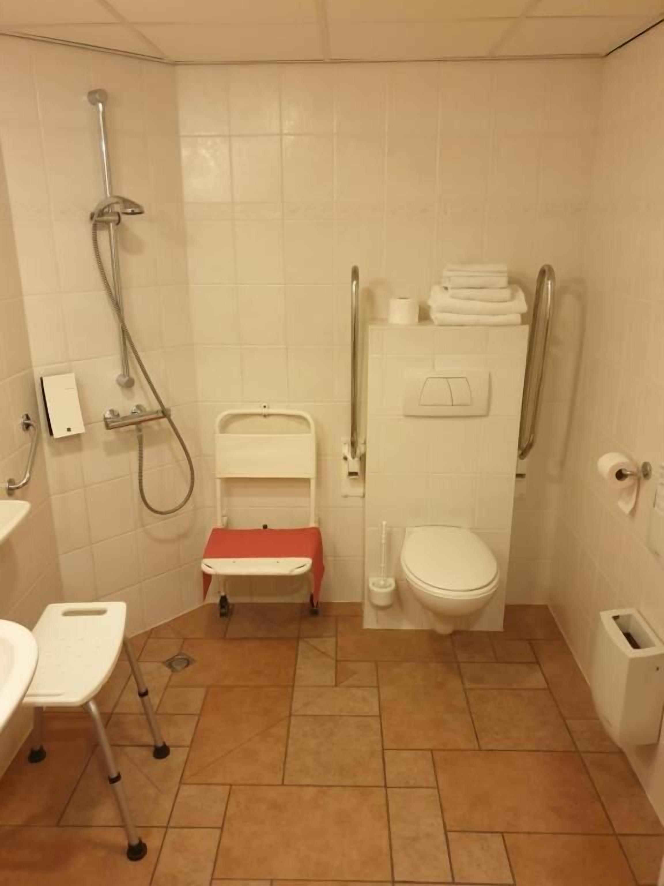 A bathroom with a shower, toilet, and sink.