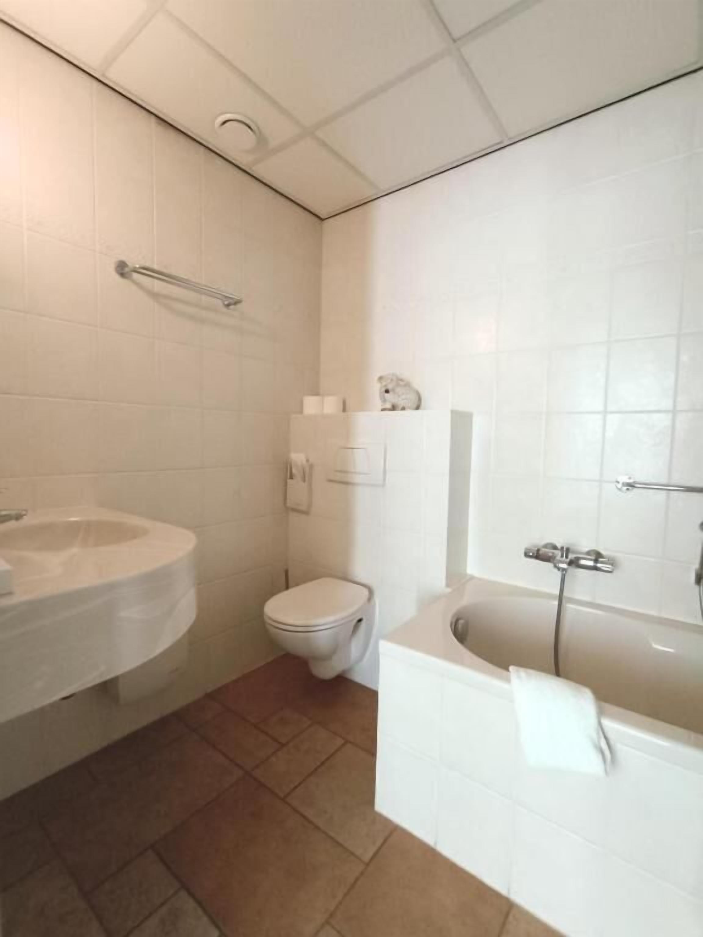 Ein Badezimmer mit Toilette, Waschbecken und Badewanne.