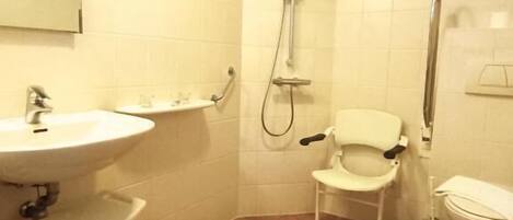 Un baño con lavamanos, espejo, inodoro y ducha.