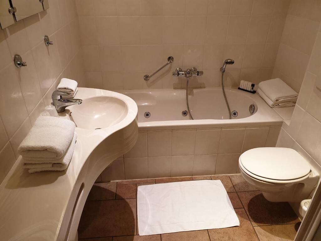 A bathroom with a sink, bathtub, and toilet.