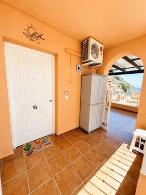 A room with a white door, a tiled floor, a radiator, and a view through an archway. - Seagull Lookout (Mojácar)