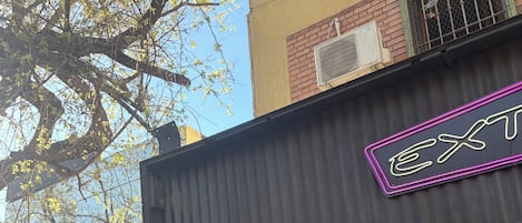 Un escaparate con un letrero de neón, un escaparate de vidrio y un toldo metálico.