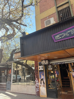 Une devanture de magasin avec une enseigne au néon, une vitrine en verre et un auvent en métal.