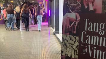 Cena noturna de rua com um cartaz anunciando 'Tang Camilo del Vino'.