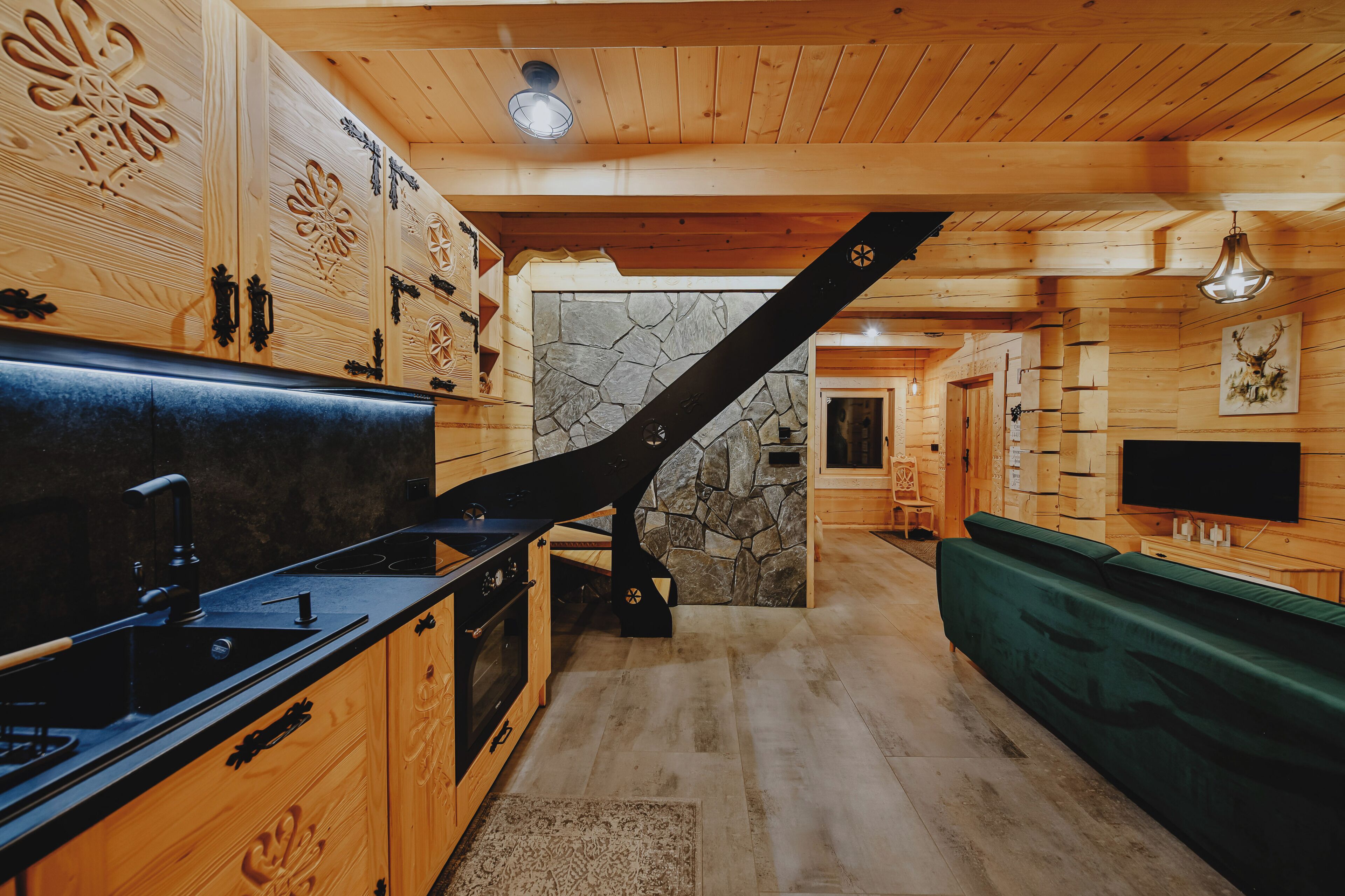 Un interno in legno con una cucina, un muro in pietra e una scala.