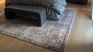 Un dormitorio con cama, mesitas de noche, lámpara de pie, ventilador de techo y ventana.