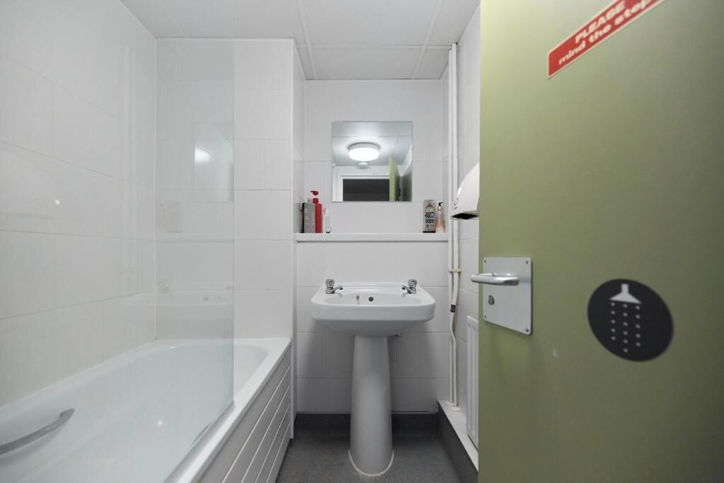 A bathroom with a bathtub, a sink, and a mirror.