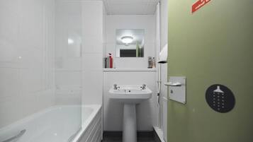 A bathroom with a bathtub, a sink, and a mirror.