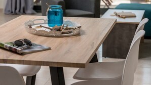 A dining area with a table, chairs, and a view of an outdoor pool area. - Elmara Lux Seaside Villa 1 Private Pool in Crete (Faistos)