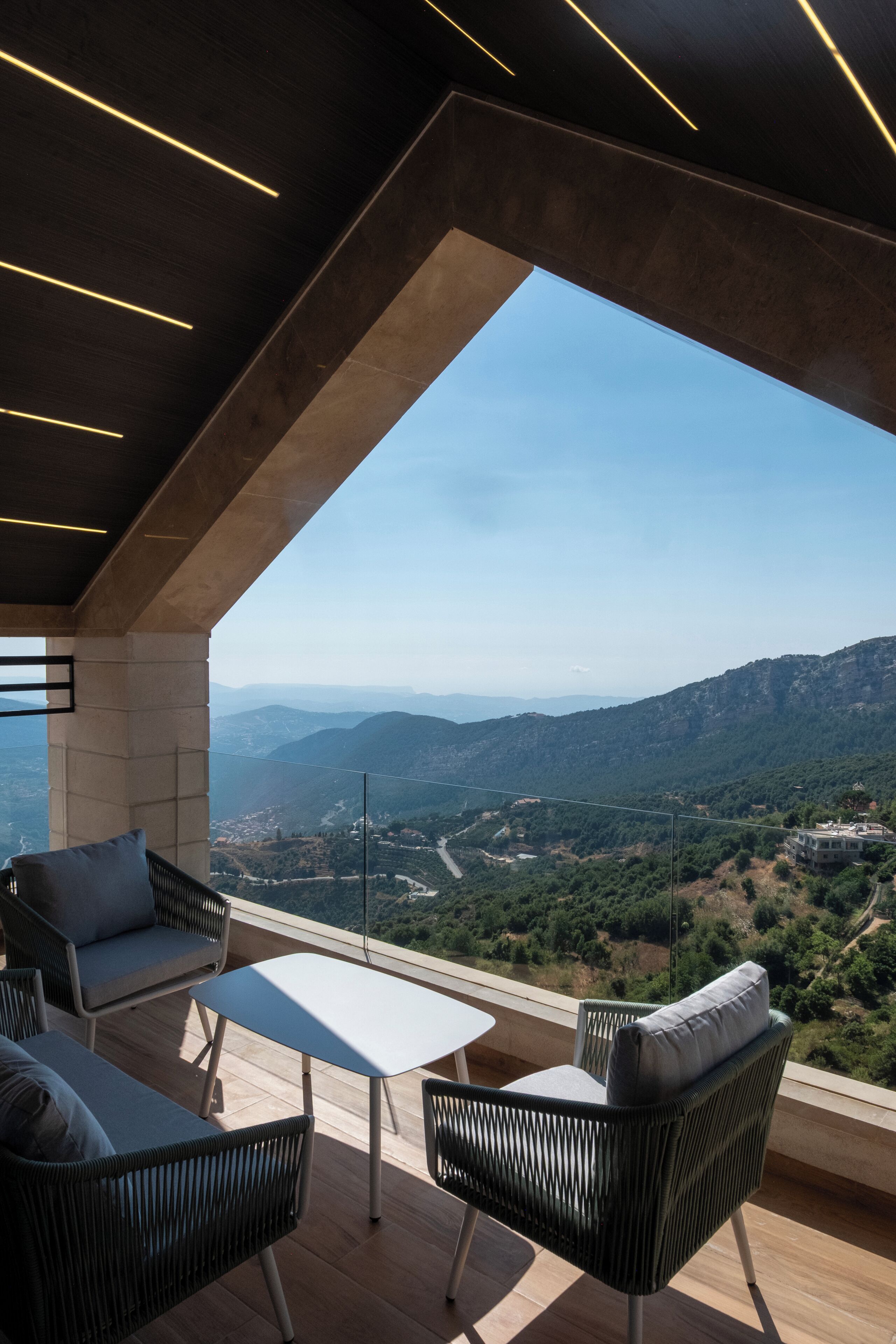 A modern outdoor seating area with a view of a mountainous landscape.