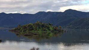 Un lac paisible avec une petite île couverte d’arbres, entourée de montagnes.