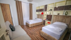 A hotel room with two beds, a sofa, a wooden wardrobe, and a window with curtains. - Private Luxury Villa with Pool, River Views (Shkodër)