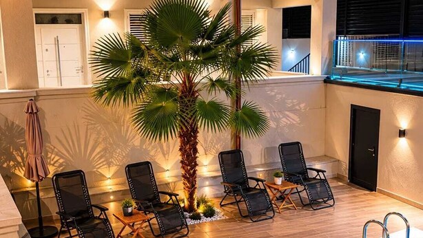 A poolside area with lounge chairs, a palm tree, and a swimming pool. - Private Luxury Villa with Pool, River Views (Shkodër)