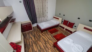 A hotel room with a wooden floor, two beds, a desk, and a wardrobe. - Private Luxury Villa with Pool, River Views (Shkodër)