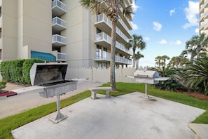 Un'area patio con una griglia, una panca e un angolo barbecue.