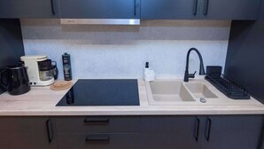 A modern kitchen with a double sink, a coffee maker, a kettle, and a toaster. - Urban 2 Bd Home in Vibrant Galatsi (Galatsi)
