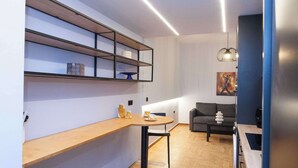 A modern kitchen with wooden countertops, a round dining table, and a built-in shelving unit. - Urban 2 Bd Home in Vibrant Galatsi (Galatsi)