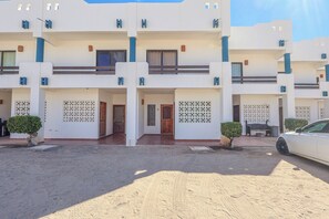 A multi-story hotel with a symmetrical facade, multiple balconies, and a central entrance. - Paradise Villa #5 | Oceanfront Escape at Playa Encanto (Puerto Peñasco)